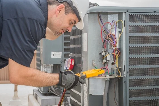 An HVAC technician maintaining commercial HVAC equipment