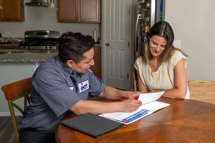 Done Plumbing, Heating, Cooling and Electric technician shaking hands with a Denver homeowner at the front door