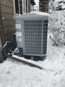 Heat pump outdoor unit installed in snowy Denver backyard