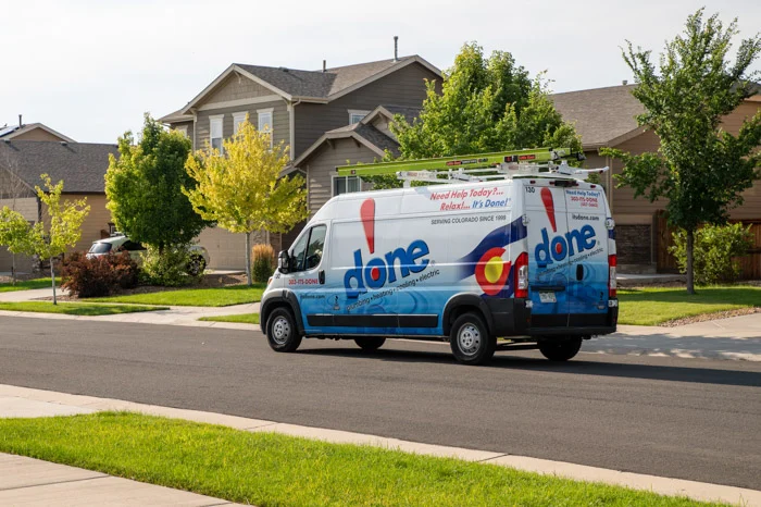 A Done branded service van with Colorado graphics parked on a tree-lined residential street in Aurora.