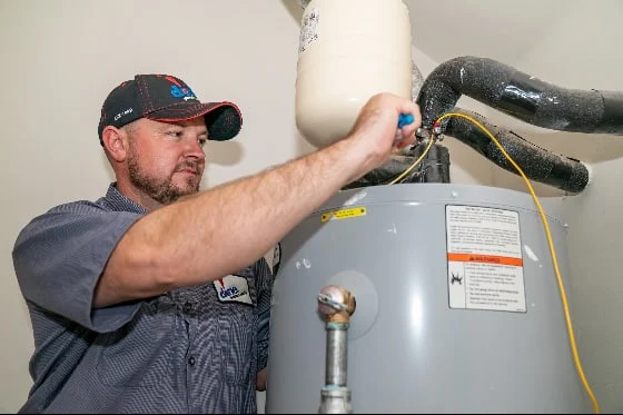 A Done! plumber completing water heater repair work on a tanked water heater