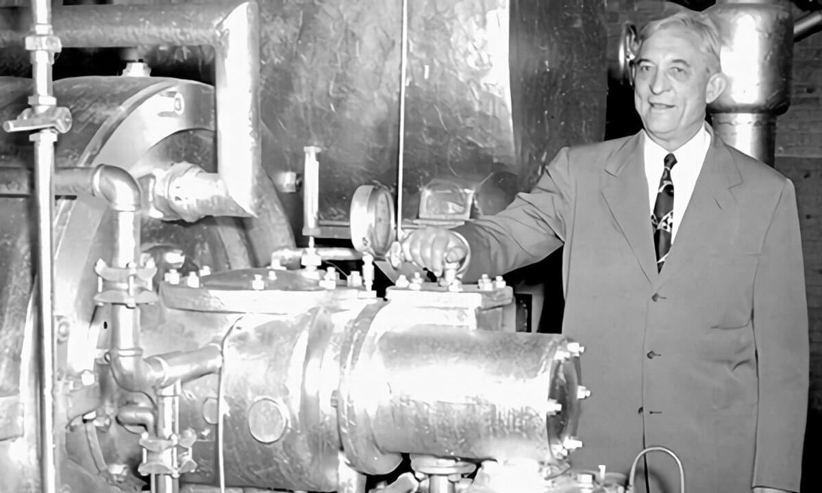 A man with an old AC unit in a black and white photo