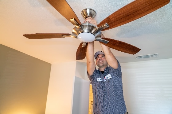 A Done Electrician installing a ceiling fan