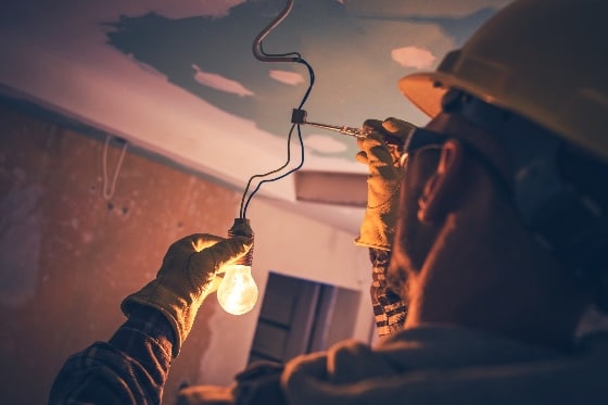 A photo of an electrician installing a lightbulb