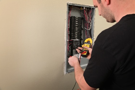 A person testing the electrical flow of a home panel