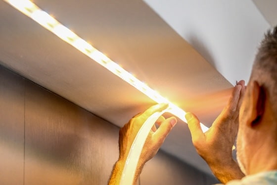 A person installing LED strip lighting