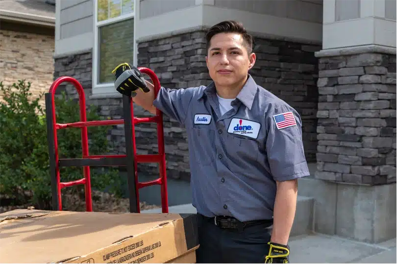 A Done HVAC technician stands with a new AC system ready