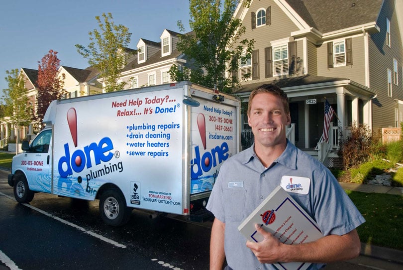 A Done technician and box truck outside a home.