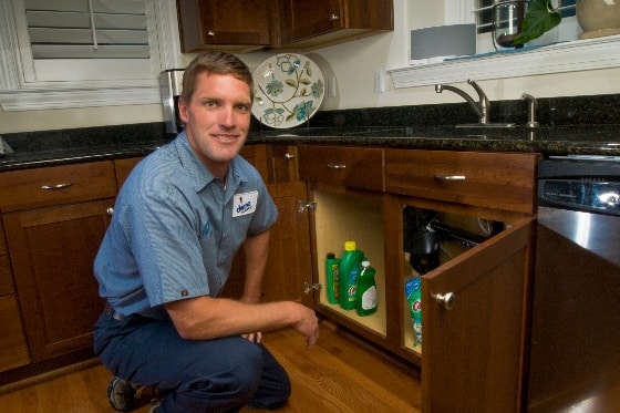 A Done plumber preparing to work under a kitchen sink