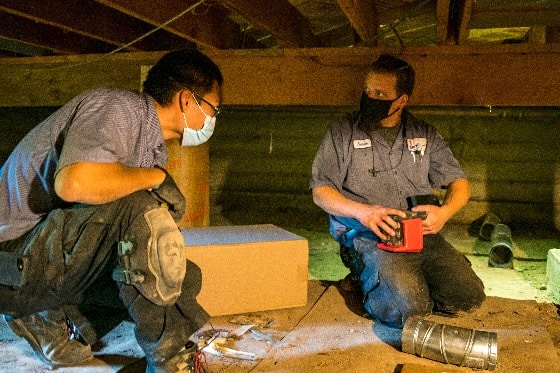 Two Done technicians installing ducting in an attic