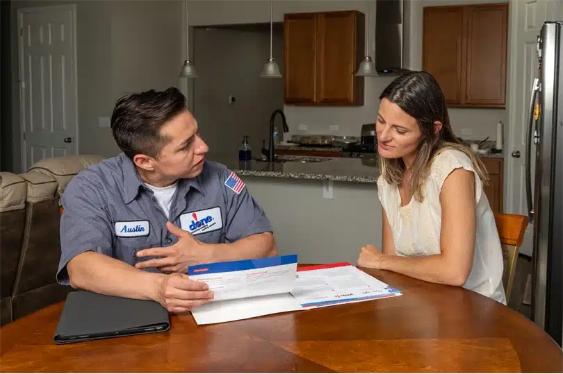 A friendly Done employee and customer at a table discussing documents