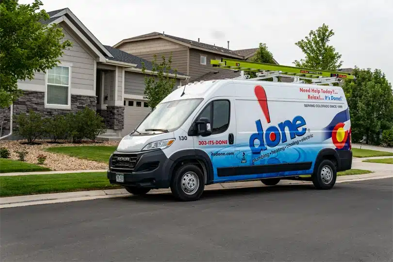 The Done Plumbing, Heating, Cooling, & Electric van parked on a street in a residential neighborhood