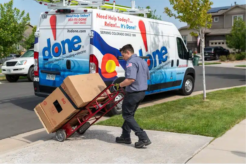 A Done HVAC Technician rolls in a new HVAC system to a home