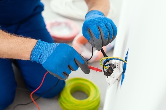 An electrician repairing an outlet