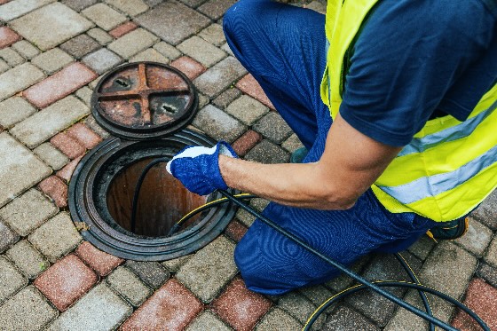 Technician hydrojetting sewer drains