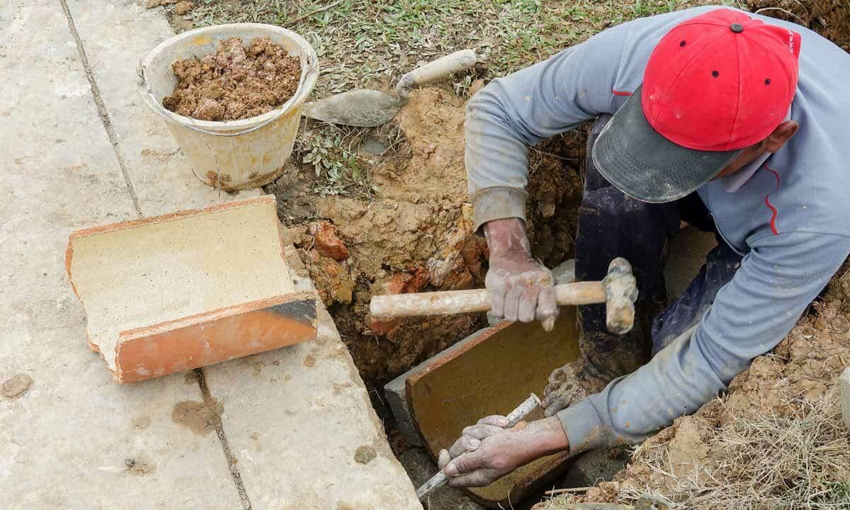 A person working on repairing a sewer line underground