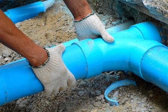 A photo of water line pipes being placed in the ground
