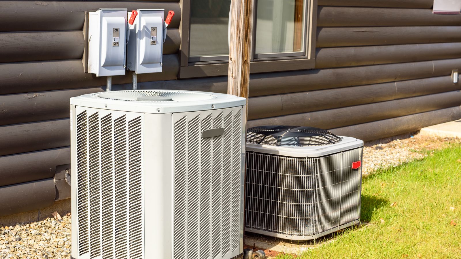 Two AC units outside a home, one is being tested