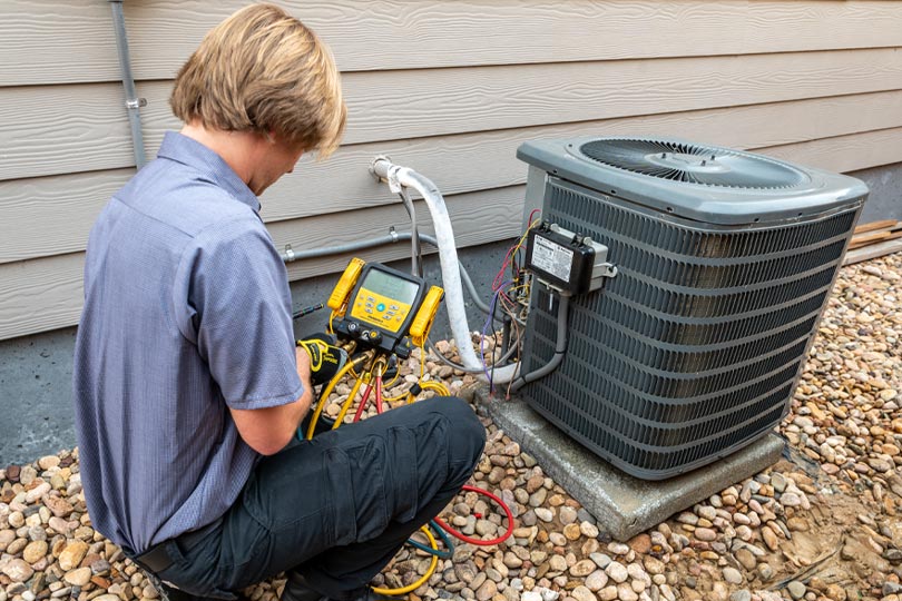 HVAC technician conducts air conditioning maintenance