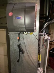 Carrier whole-home humidifier mounted on the duct system to add moisture to dry indoor air during Colorado’s winter months.