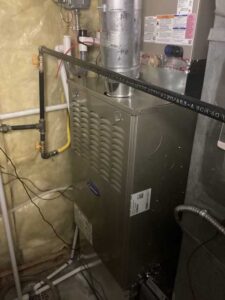 Newly installed Carrier gas furnace with gas line and condensate drain in Centennial home