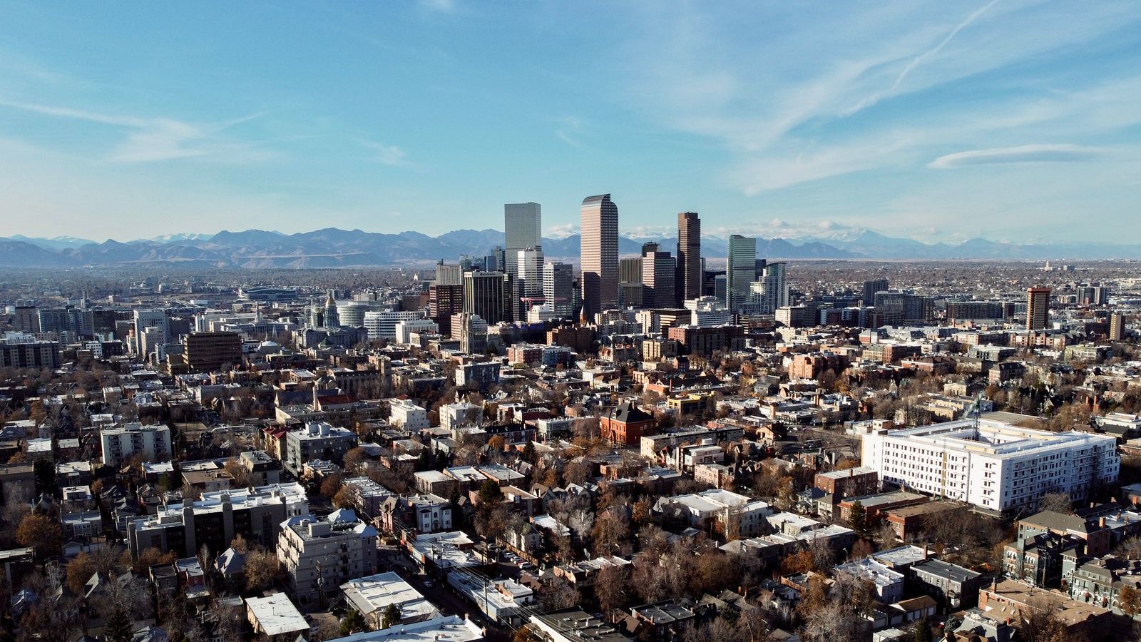 Aerial view of downtown Denver with the Rocky Mountains in the background