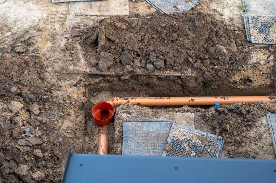 Underground Sewer Pipe Installation at Construction Site.