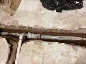 A replaced pipe in the excavated hole in a home's basement in Denver