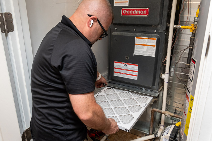 HVAC technician inspects a furnace air filter