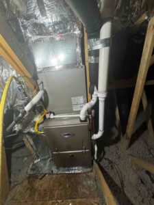 New Carrier Infinity 96% furnace installed in the upper-floor mechanical closet, complete with updated PVC venting, drain line, and gas connections for safe, efficient operation.