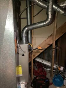 New high-efficiency furnace installed with updated metal venting and gas connections for safe and reliable heating.