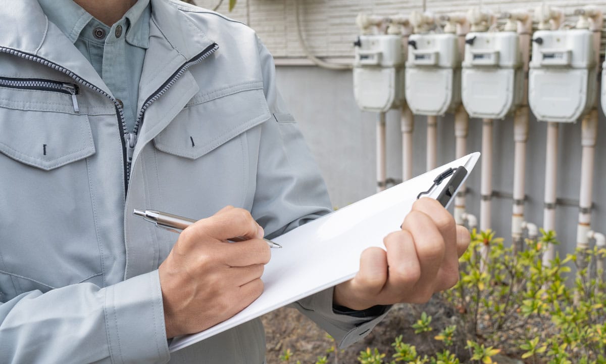 Inspector with gas line meters in the background