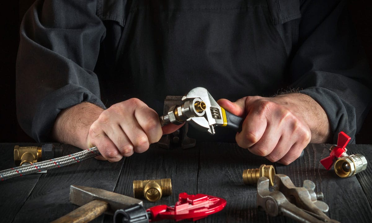 Person working with a wrench and pipes