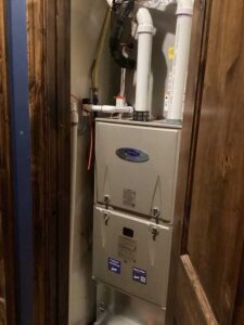 Carrier Infinity heat pump air handler and 96% furnace installed in the attic, with reworked venting, insulated refrigerant lines, and new drain configuration for reliable cold-climate performance.