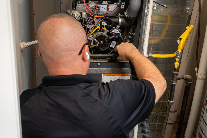 HVAC technician conducts furnace maintenance