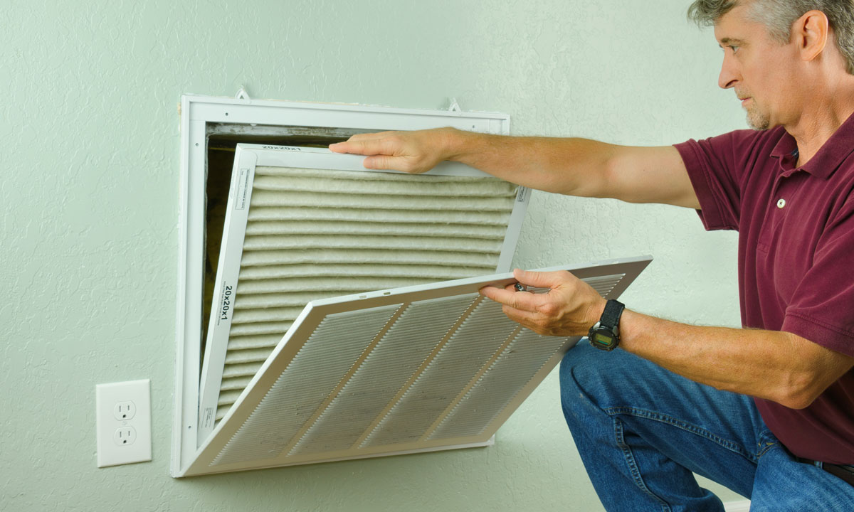 A person replacing the air filter in their home HVAC system