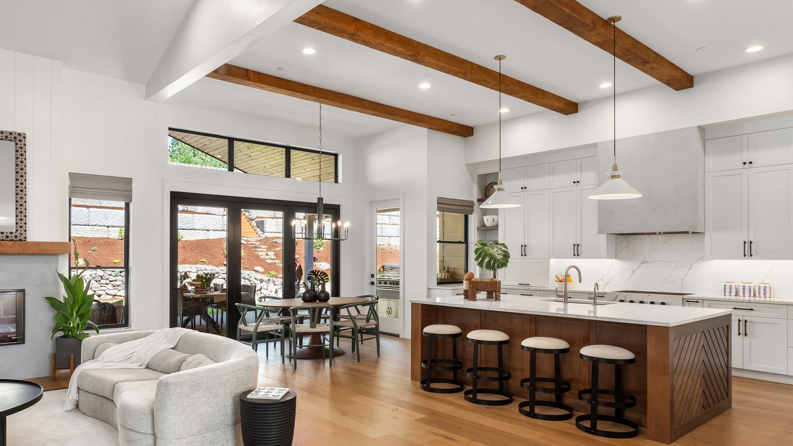 A modern kitchen with pendant lights, island, and cabinet lighting on