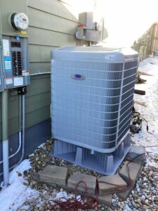 Carrier Infinity cold climate heat pump installed outside a Thornton home on a new equipment pad