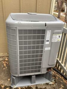 An HVAC condenser unit installed outside a home on a concrete slab in Westminster CO