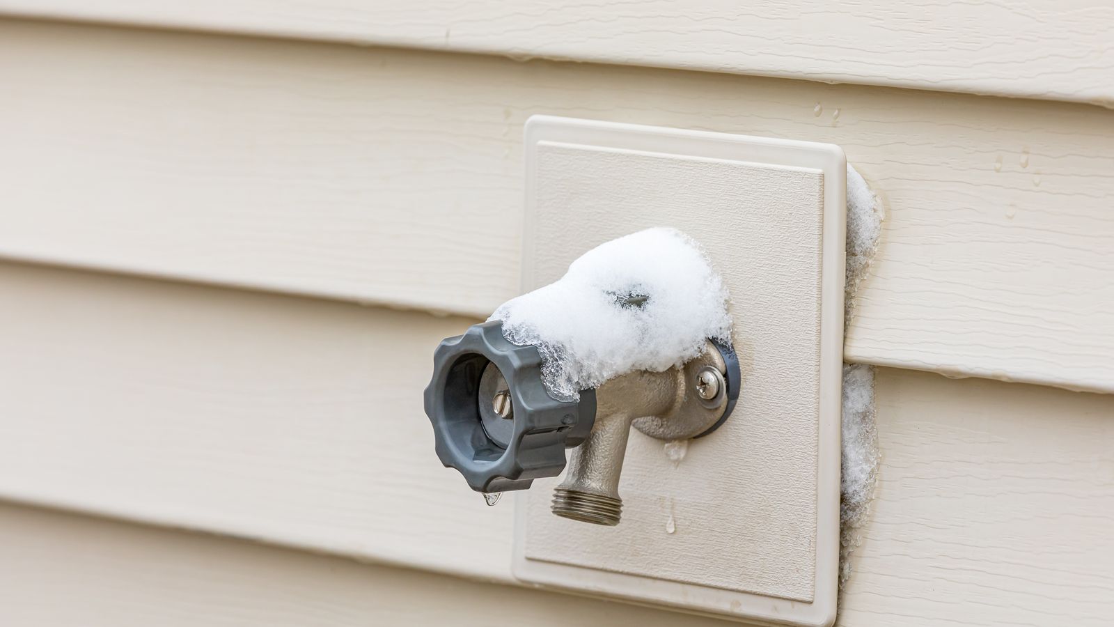 Snow piling on top of an outdoor faucet