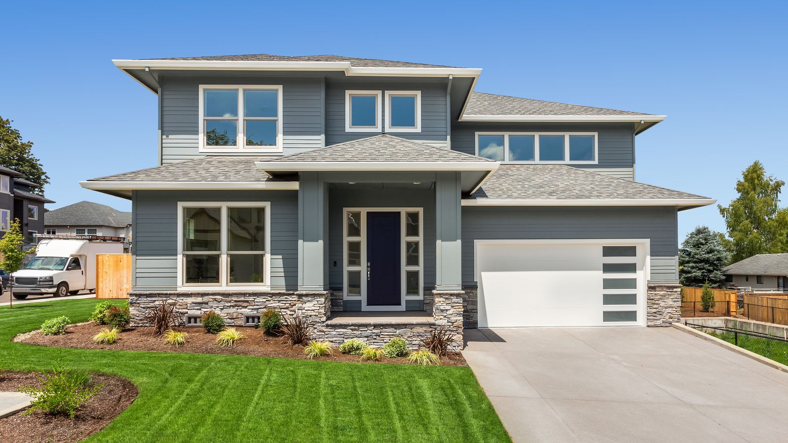 The front view of a modern home with garage on a bright summer day