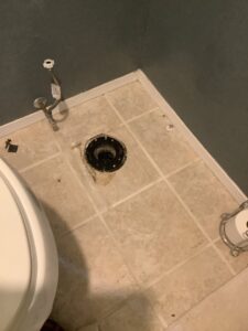 Hole beneath toilet after it was removed from the floor