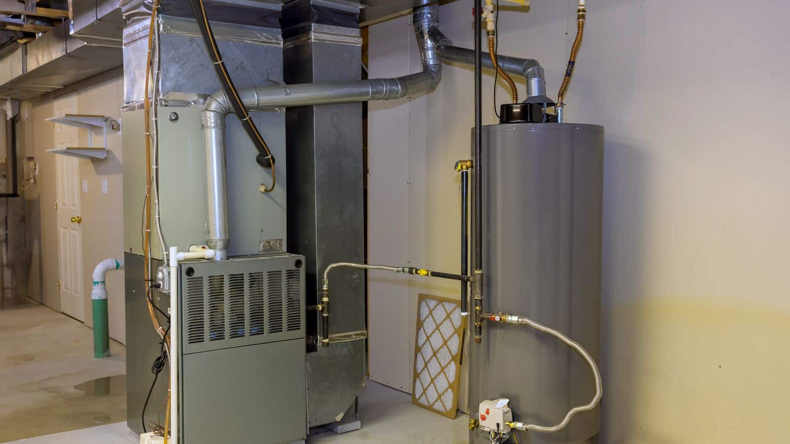 Heating system with water heater and furnace located in a basement of a home